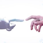 Una mà d'un robot i una mà d'un humà a punt de tocar-se