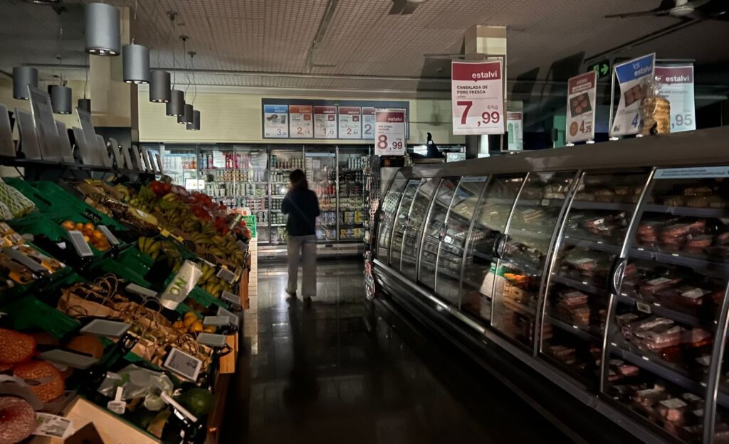 Un passadís del supermercat a les fosques i un client intentant comprar
