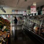 Un passadís del supermercat a les fosques i un client intentant comprar