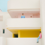 Xavier Coca i Oriol de Ramon vestits amb tons blaus i roses en un balcó d'un edifici