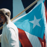 Bad Bunny amb una bandera de Puerto Rico al videoclip de 'La mudanza'. (Captura de pantalla / YouTube)